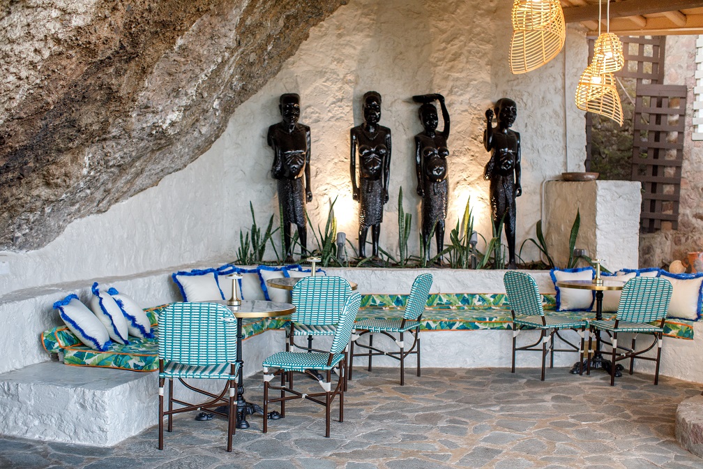 The Saltfish dining area with carved figures and blue chairs